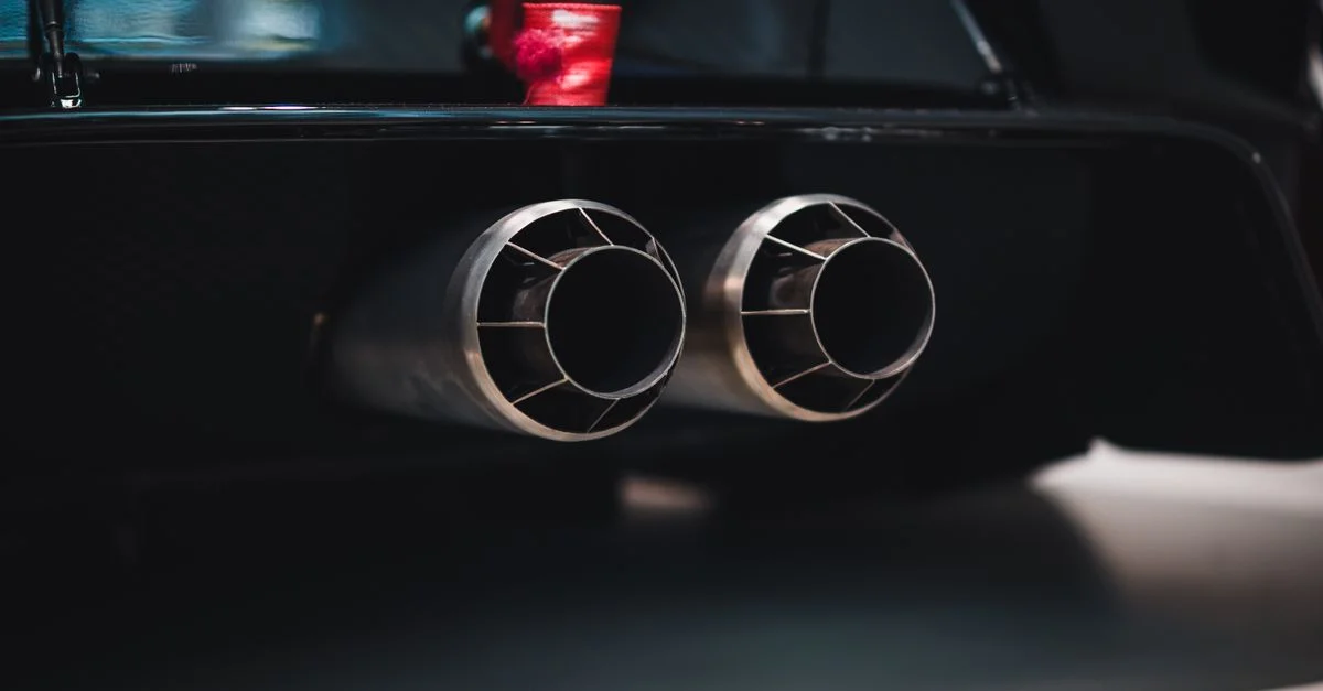 Gros plan sur des tuyaux d'échappement doubles d'une voiture élégante, avec un accent sur le détail et le design.