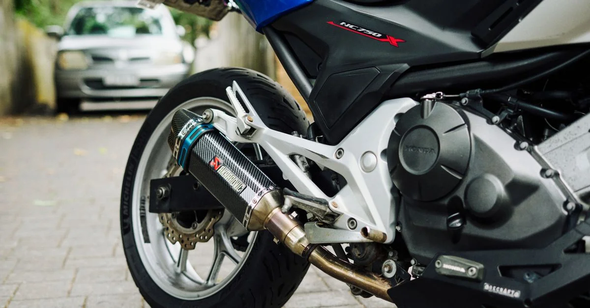 Vue détaillée d'un échappement de moto modifié dans une ruelle d'Auckland.