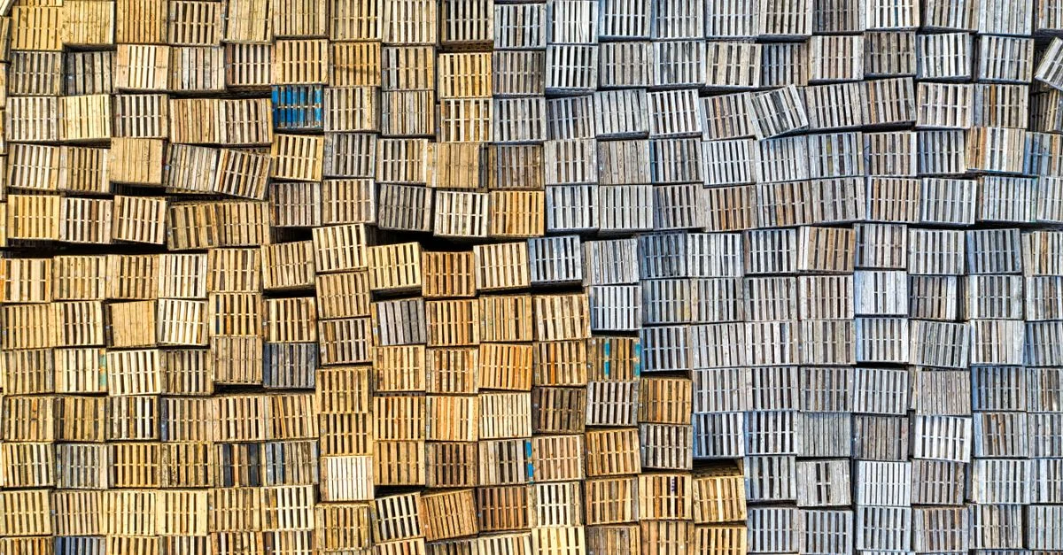 Vue aérienne de palettes en bois empilées créant un motif texturé en extérieur.